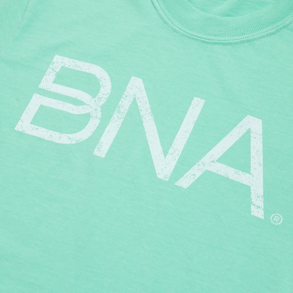 Close-up of mint green crewneck t-shirt with white distressed BNA logo centered on the chest.  BNA logo features a unique infinity "B."