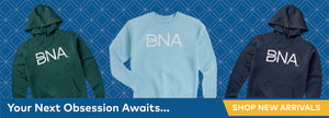 Get cozy in a new BNA sweatshirt this winter.  Blue background with festive tonal diamond pattern background.  Pine green hoodie w/ BNA logo, light blue crewneck w/ white BNA logo, and steel blue hoodie with white BNA logo are featured products.  "Your Next Obsession Awaits..." at the bottom with Shop New Arrivals.  Links to New Arrivals category.