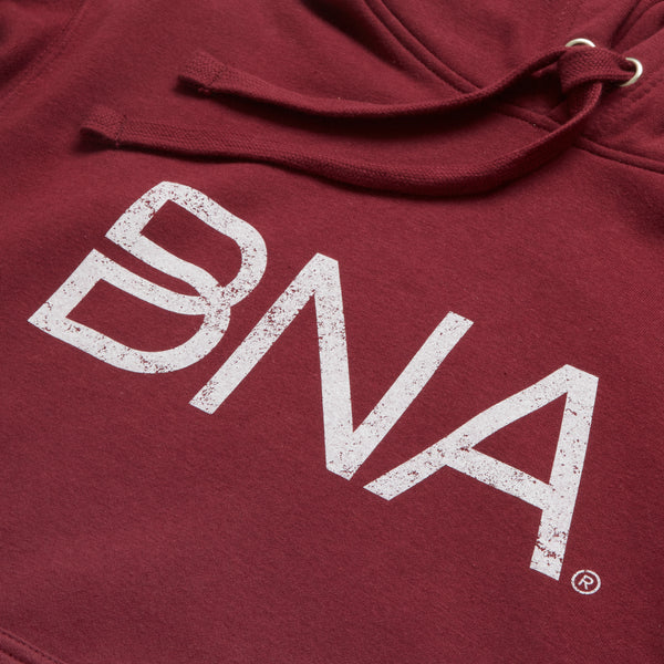 detail shot of white distressed BNA logo on maroon hoodie 