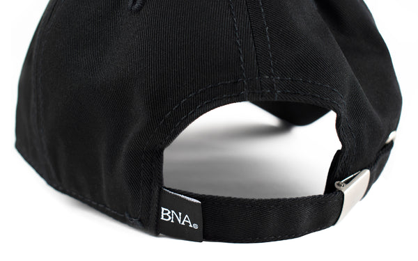 Back detail of hat with metal closure and woven tag in black with BNA in white lettering.