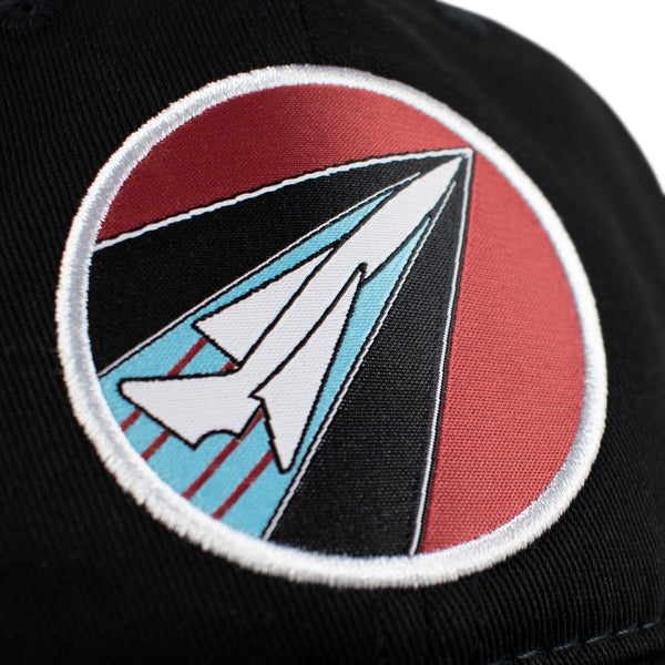 Close-up of woven logo patch.   It is a woven patch featuring red background and white outline of a plane.  