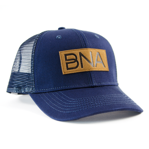 Front view of Navy BNA Patch Trucker Hat.  Navy blue hat with mesh back and sides, brown BNA logo patch.