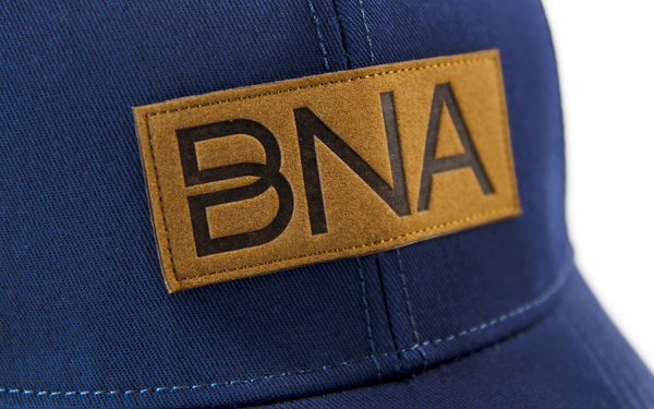 Detail view of BNA Logo patch on Navy BNA Patch Trucker Hat