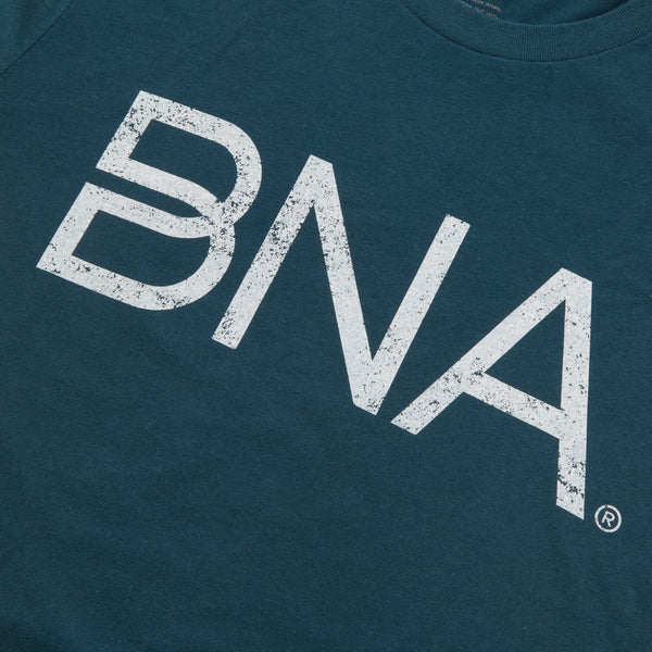 Detail view of distressed white BNA logo on dark teal unisex t-shirt.
